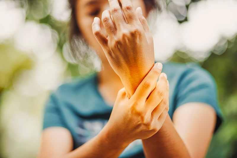 woman holding the joint of her wrist in pain