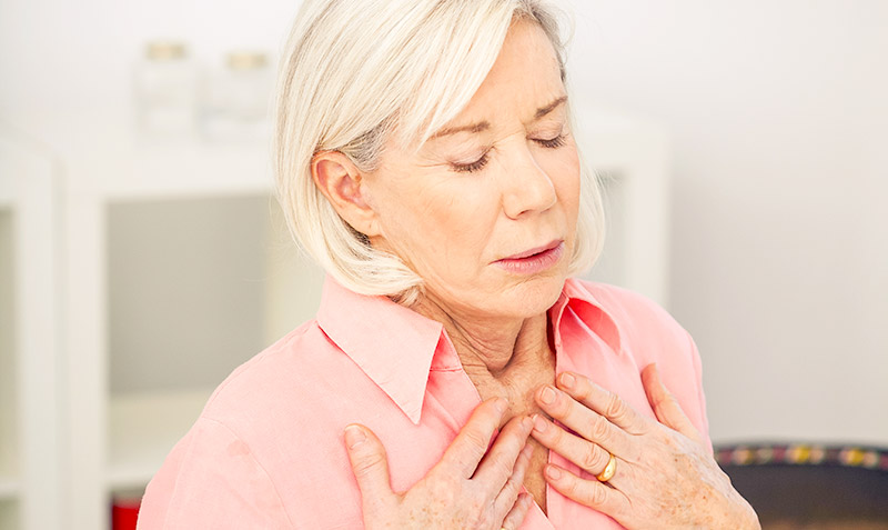 older woman holding her chest in pain