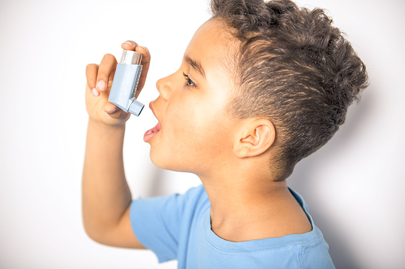 child with ashthma holding inhaler
