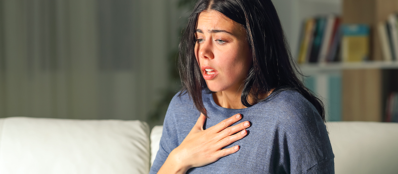 Woman experiencing anxiety, holding her chest
