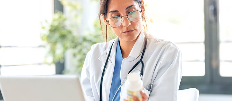 female doctor holding prescription bottle