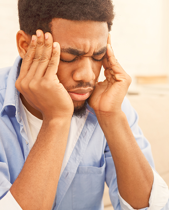man with sinus headache holding his head in pain
