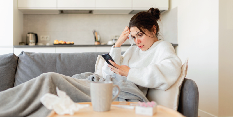 Woman with flu scrolling through her phone