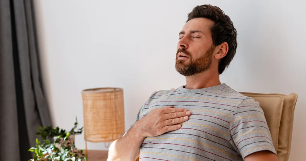 Man experiencing right-side chest pain while sitting.