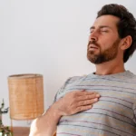 Man experiencing right-side chest pain while sitting.