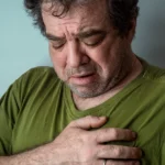 A man experiencing anxiety, holding his chest in pain.