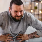 Man holding stomach showing stress-related diarrhea symptoms