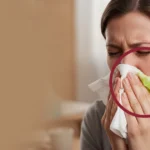 Woman blowing nose with green mucus highlighted.
