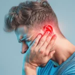Man holding his ear in pain, showing earache or ear infection symptoms.