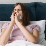 erson lying in bed, struggling to breathe with blocked nose.