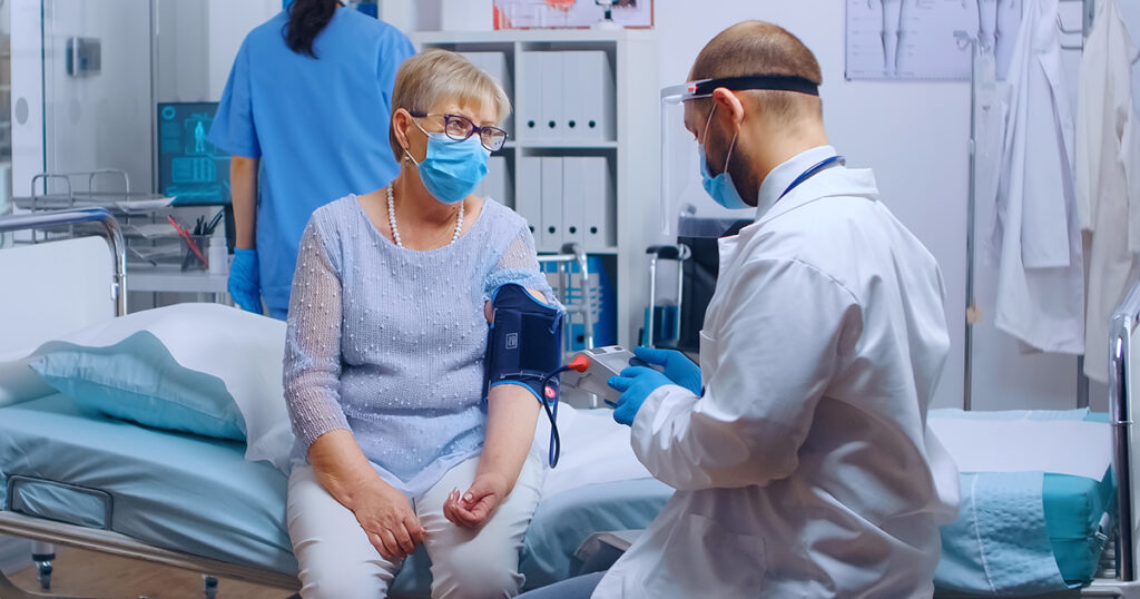 A doctor checks the blood pressure of a patient in a medical clinic, demonstrating ways to manage hypertension.
