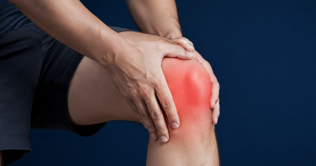 Man holding a swollen red knee in pain.