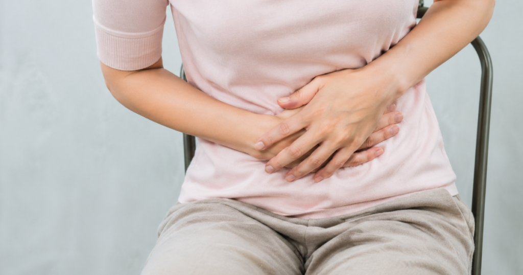 Woman holding lower abdomen in pain.