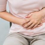 Woman holding lower abdomen in pain.