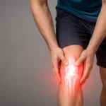 Man holding an inflamed, painful knee.