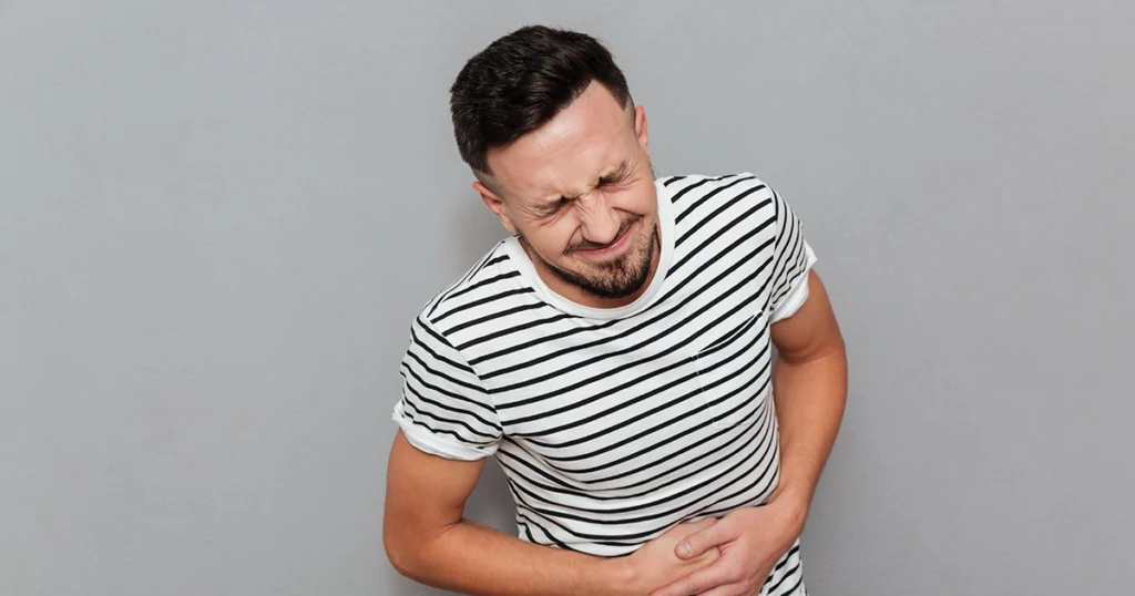 A man holding his abdomen in pain.