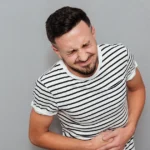 A man holding his abdomen in pain.