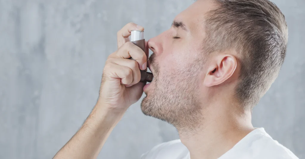 portrait-young-man-using-asthma-inhaler