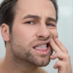 Man examining his severely dry, cracked lips and white tongue.